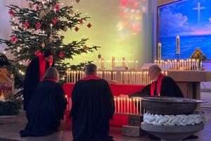 Das Pfarrteam der neuen Gemeinde "Havenkirche" entzünden Kerzen um Altarraum der Christus- und Garnisonkirche.