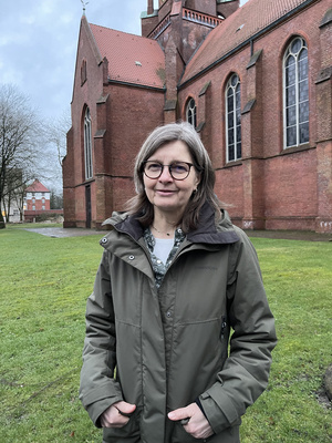 Auf dem Bild sieht man Frau Martina Eckhoff vor einer Kirche