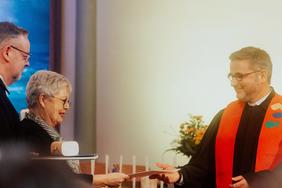 Kreispfarrer Christian Scheuer und Synodenpräsidentin Sabine Blütchen überreichten die Urkunde und das neue Siegel an Pfarrer Rainer Claus.